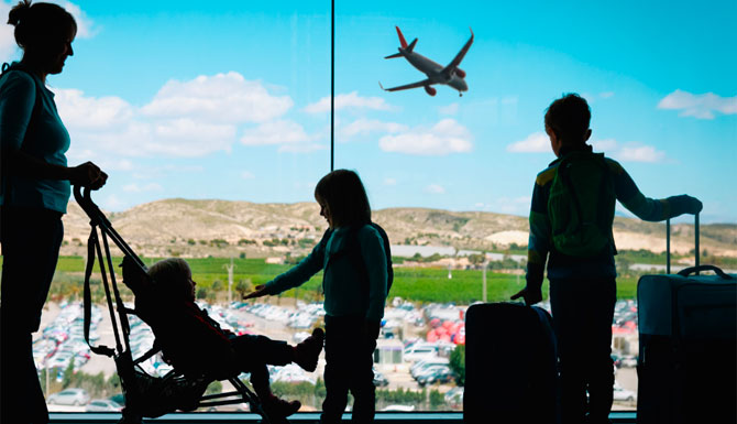 Family with suitcases at the airport overlooking a plane landing. Boston Chauffeur Limousine Service