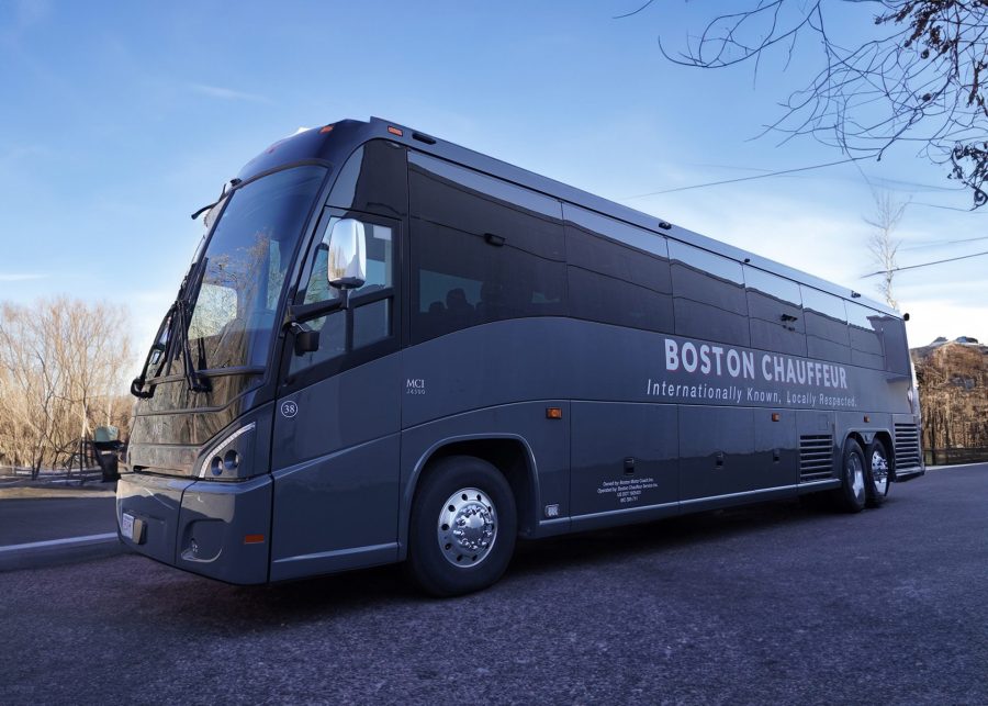 Boston Chauffeur's 55 passenger coach bus exterior view traveling on the road.