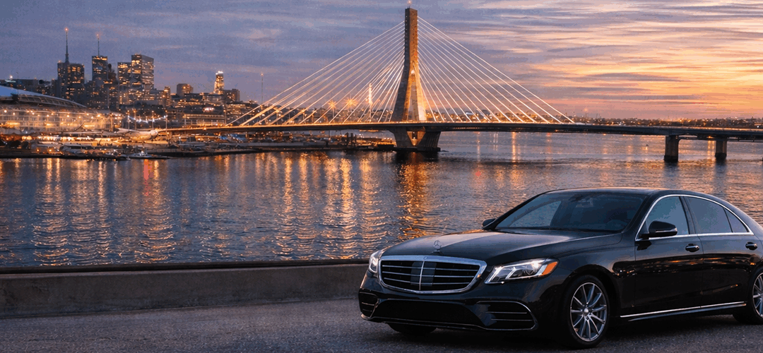 Black Mercedes Sedan in front of a Twilight sky over Boston with ZakimBridge
